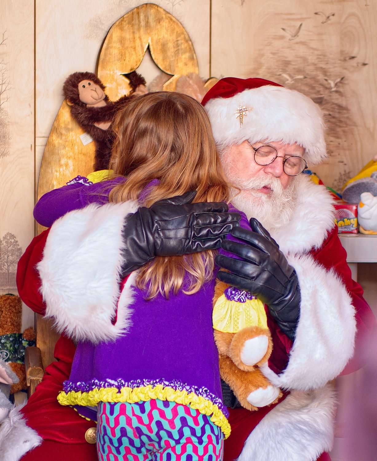 Kymber Echols gets a hug from Santa. [see some more of Santa's stop]